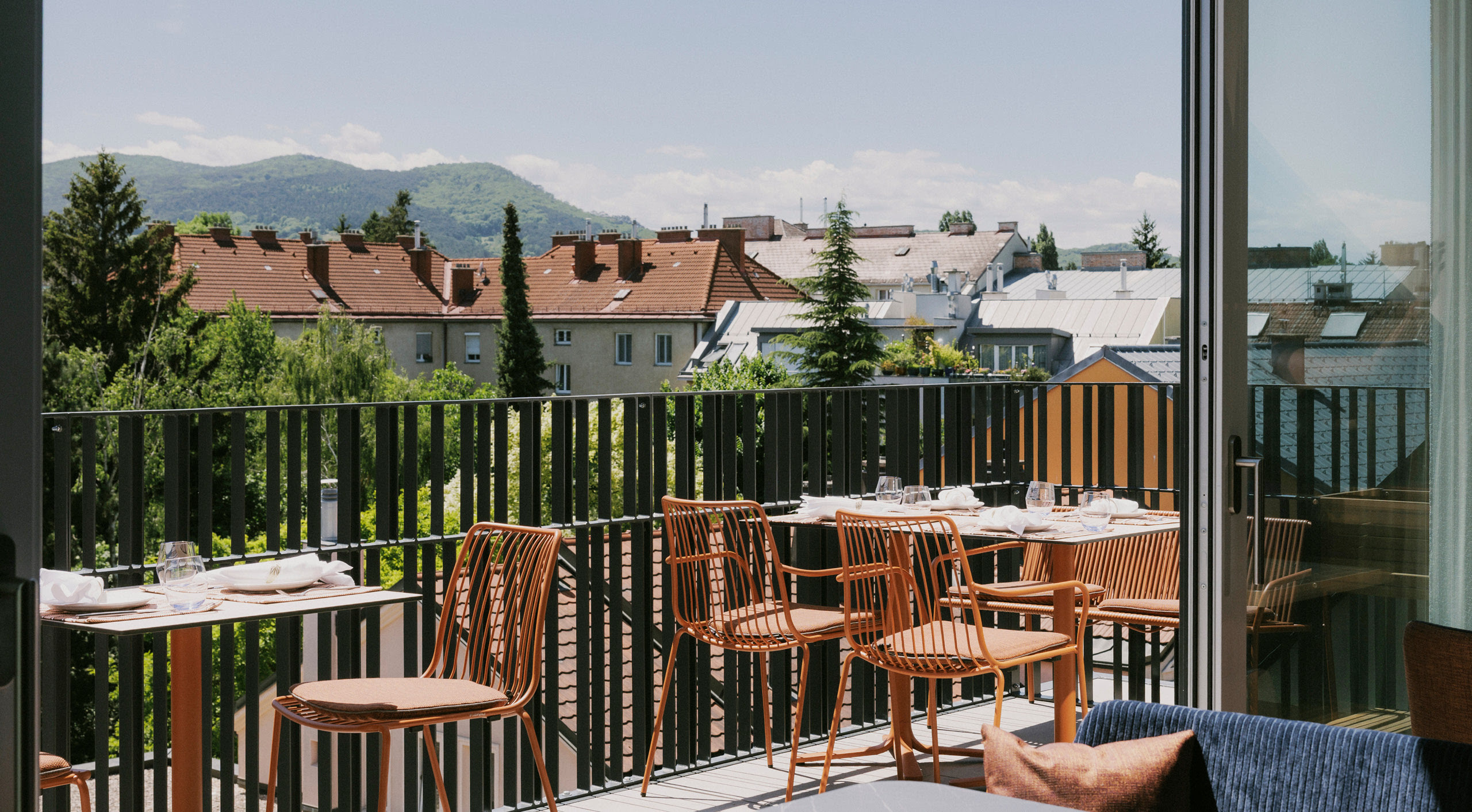 Elegant m&ouml;blierte Terasse des WILMA Rooftop mit atemberaubender Aussicht &uuml;ber die D&auml;cher Liesings.
